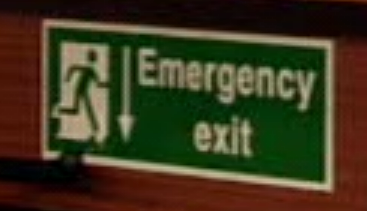 green emergency exit sign with arrow pointing down