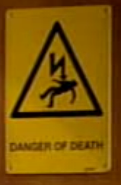 yellow sign reading 'danger of death', image of a person being electricuted above